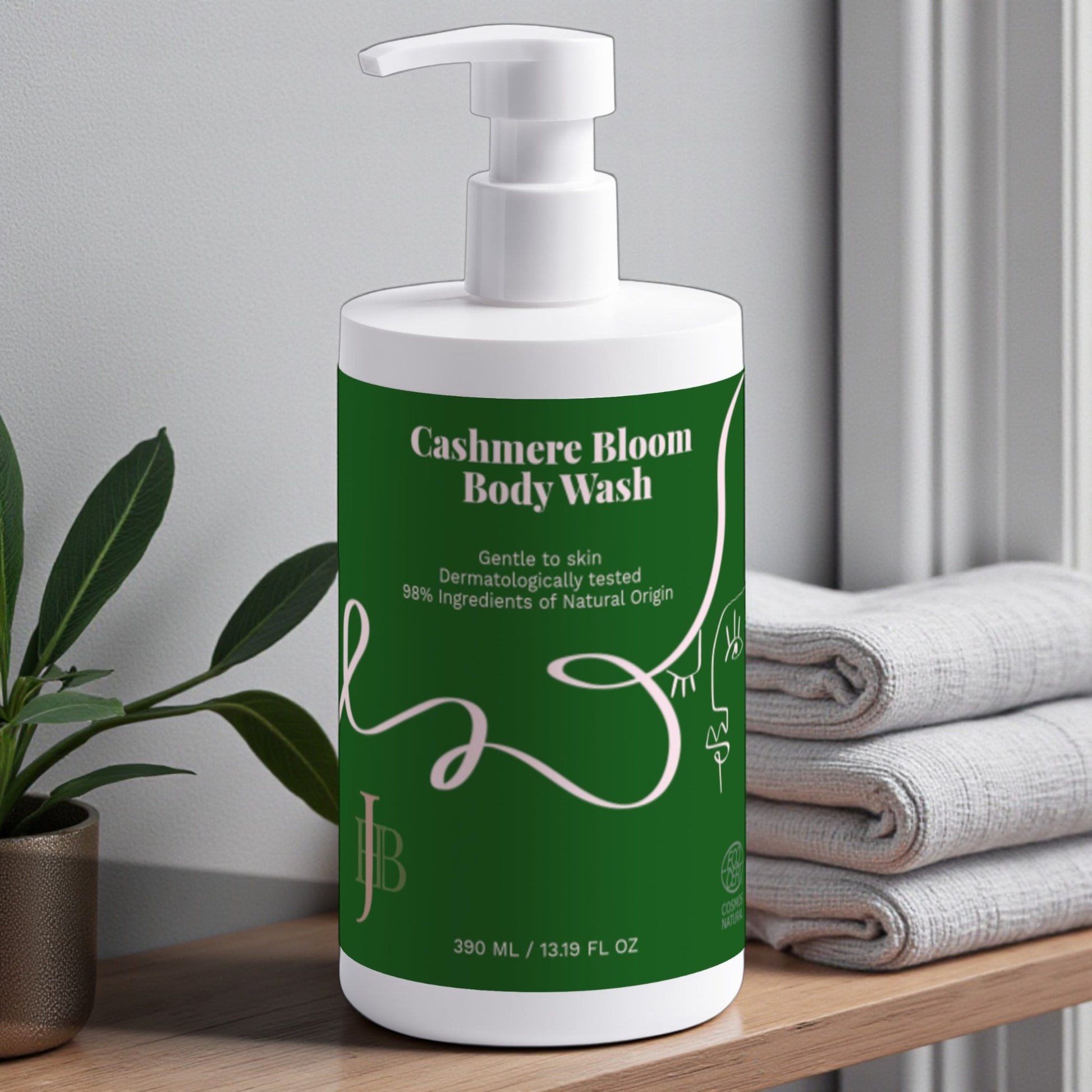 Cashmere Bloom Body Wash bottle on a wooden surface with towels and a plant in the background