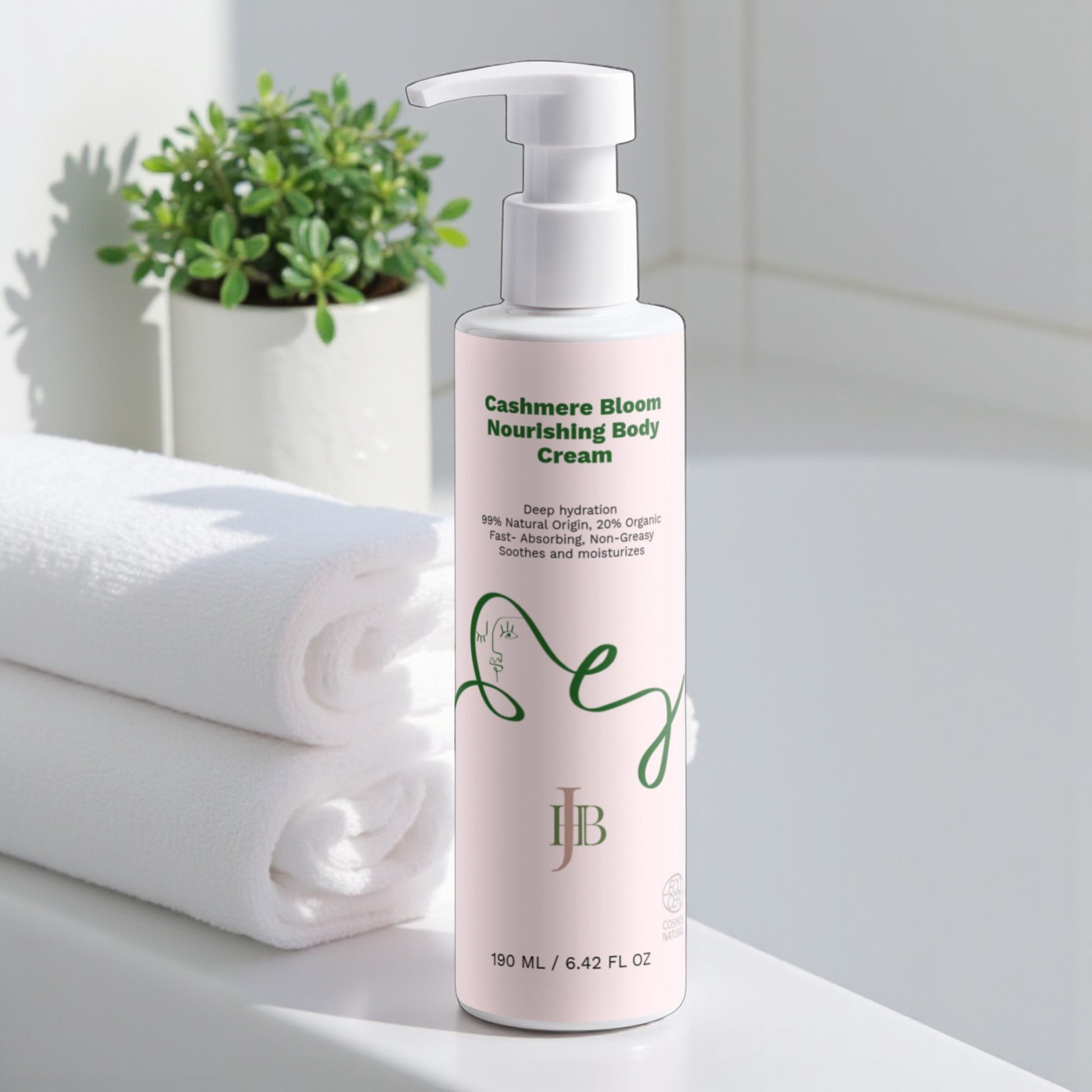 Bottle of Cashmere Bloom Nourishing Body Cream on a white surface with a plant in the background