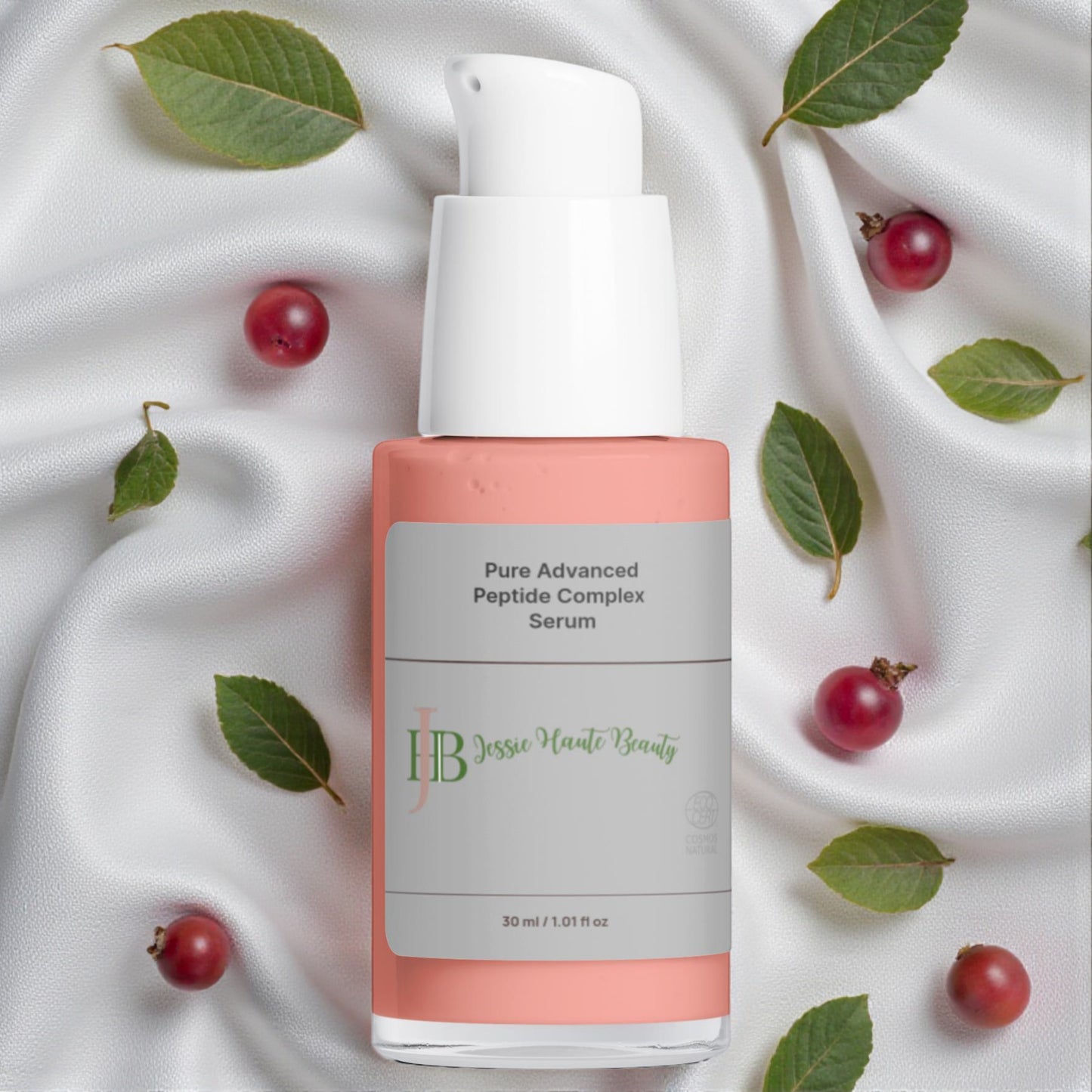 Serum bottle with green leaves and red berries on a white fabric background